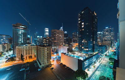 Illuminated buildings in city against sky at night