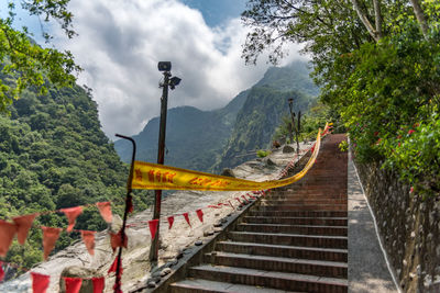 Street amidst plants and mountains against sky