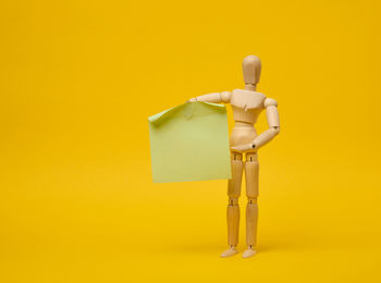 Close-up of figurine against yellow background