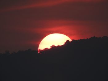 Scenic view of silhouette mountains against orange sky