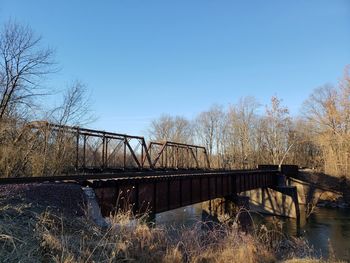 Bridge over river against clear blue sky