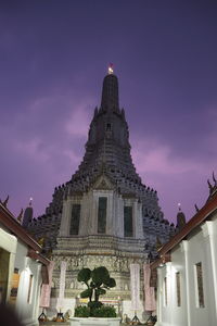 Low angle view of illuminated building against sky at dusk