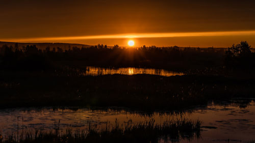 Scenic view of lake against sky during sunset