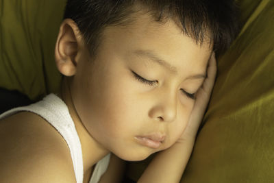 Close-up of cute boy sleeping on bed