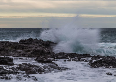 Waves splashing on rock formations at shore