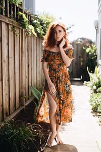 Portrait of smiling young woman standing against plants