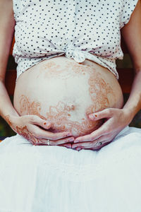 Midsection of woman with arms raised