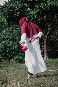 Woman with umbrella standing on field