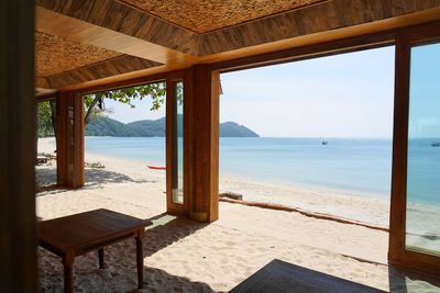 Scenic view of beach seen through window