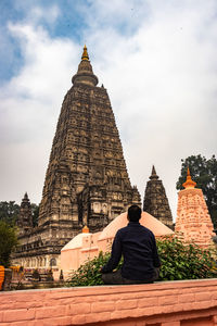 Rear view of people outside temple against building