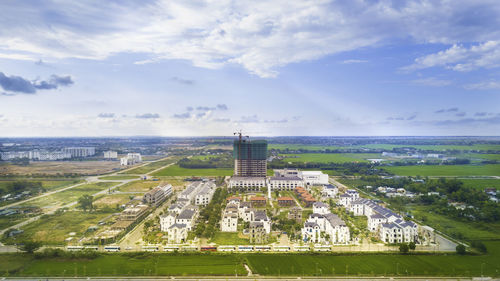 Aerial view of cityscape against cloudy sky