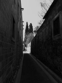 Road amidst buildings against clear sky