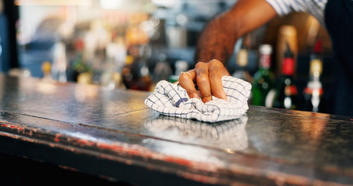 Cropped hand of woman holding heart shape on table