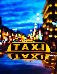 Close-up of taxi sign in illuminated city