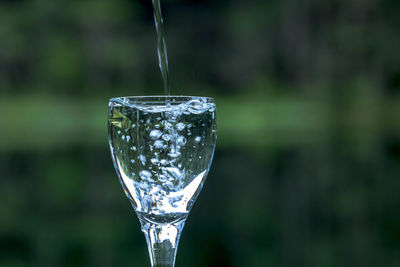 Water pouring in wineglass