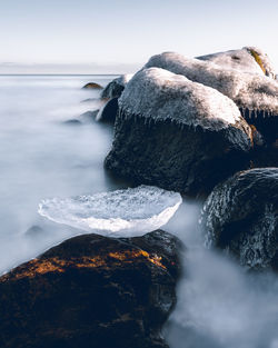 Scenic view of rocks in sea against sky