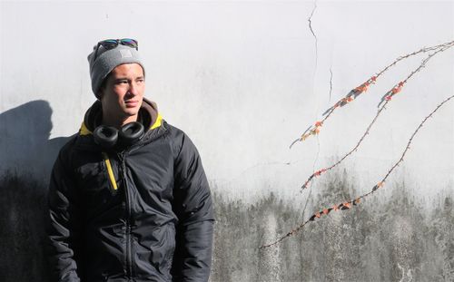 Portrait of man standing against wall