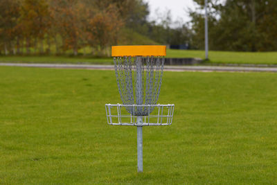 Empty benches on field against trees