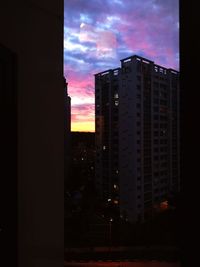 Buildings in city against sky at sunset