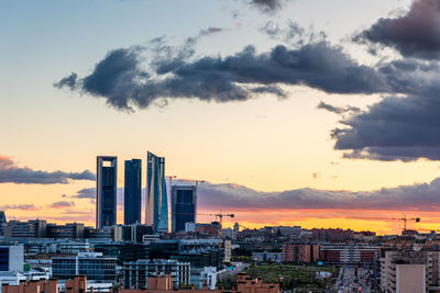 Modern buildings against sky during sunset