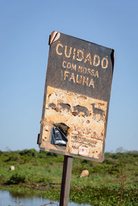 Close-up of information sign against clear sky