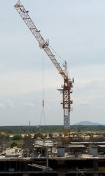 Cranes at construction site against sky