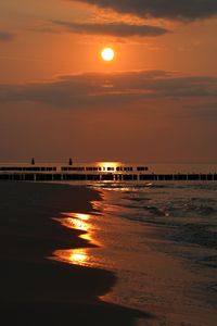 Scenic view of sea against orange sky