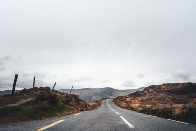 Road passing through landscape against sky