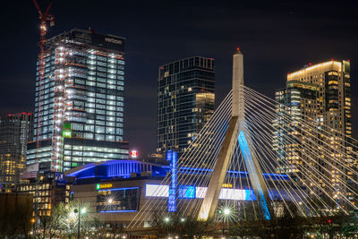 Illuminated modern buildings against sky at night