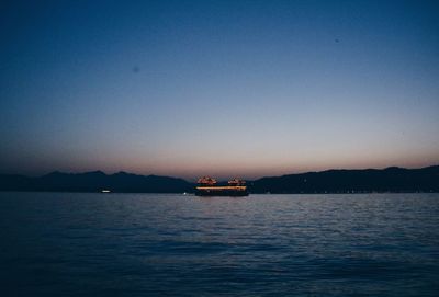 Boat sailing in sea against clear sky