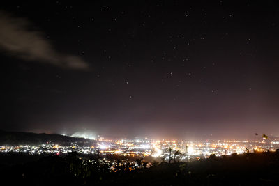 Aerial view of illuminated cityscape against sky at night