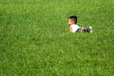 Full length of girl sitting on grassy field