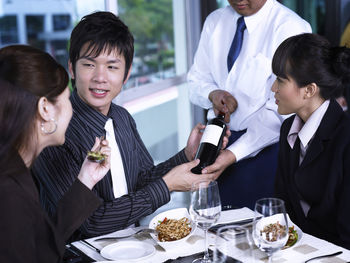 Colleagues with drinks at restaurant during meeting