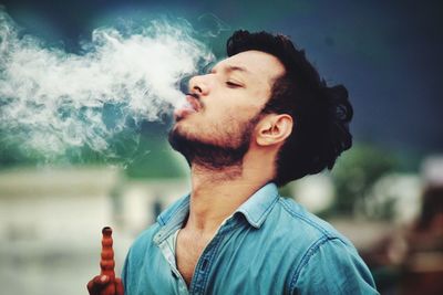 Portrait of young man smoking outdoors