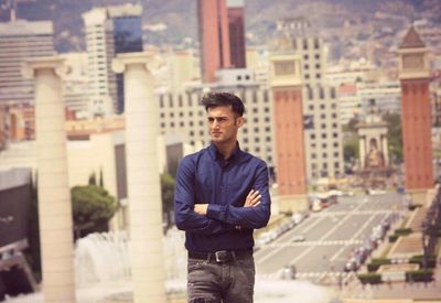 Portrait of young man standing in city