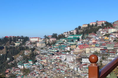 Aerial view of townscape against clear blue sky