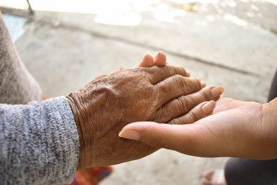 Cropped image of woman holding hands outdoors