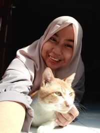 Portrait of smiling young woman with cat