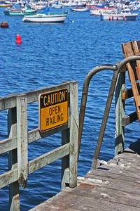 Warning sign on railing of boat in sea