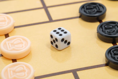 High angle view of dice and coins on checkers board