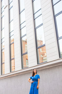 Woman standing by window of building