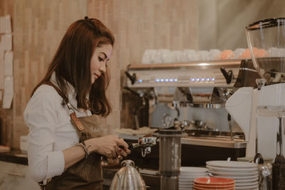 Side view of woman working in cafe
