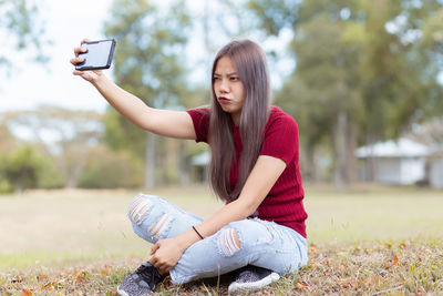 Young woman photographing with mobile phone