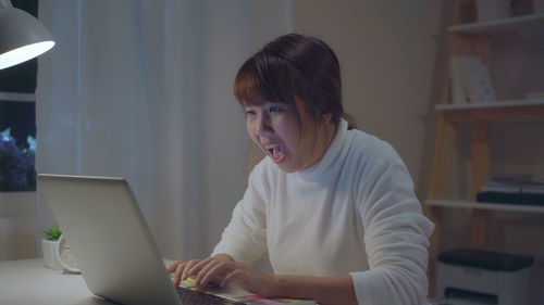 Young woman using mobile phone at home