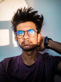 Portrait of young man against blue wall