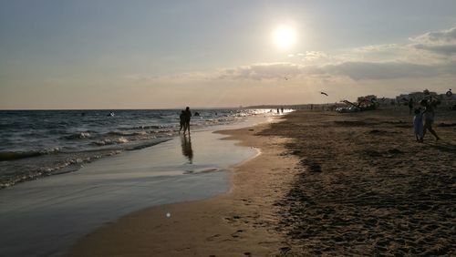 People at beach during sunset