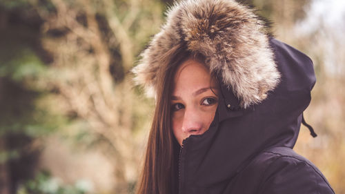 Close-up portrait of young woman wearing fur coat