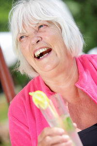 Close-up portrait of smiling woman holding ice cream