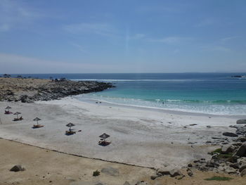 Scenic view of beach against blue sky