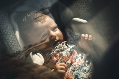 High angle of cute baby lying on car seat